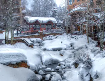 A footbridge over the creek in Beaver Creek village during snowfall