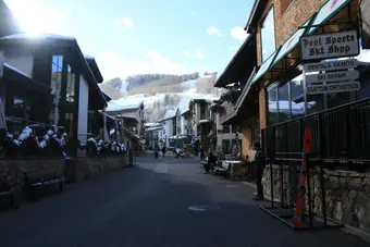 A street in Vail Village after snowfall, ski shops on both sides and the mountain behind