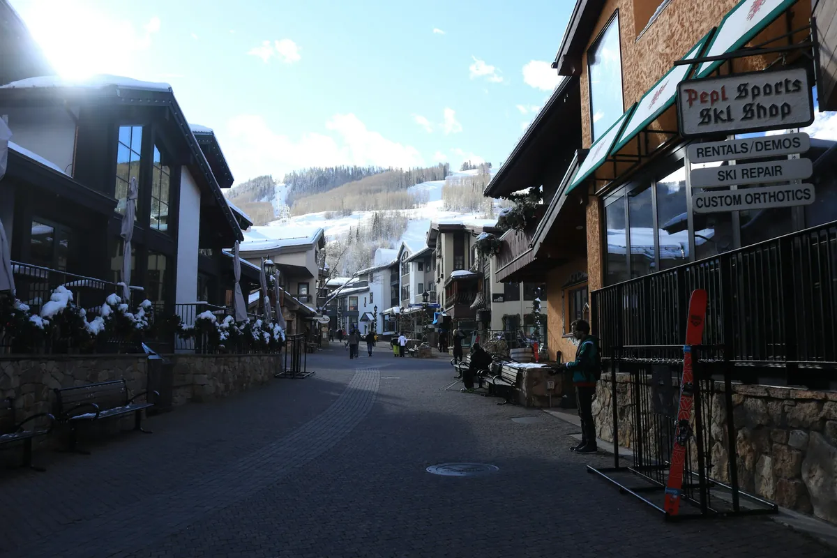 A street in Vail Village after snowfall, ski shops on both sides and the mountain behind